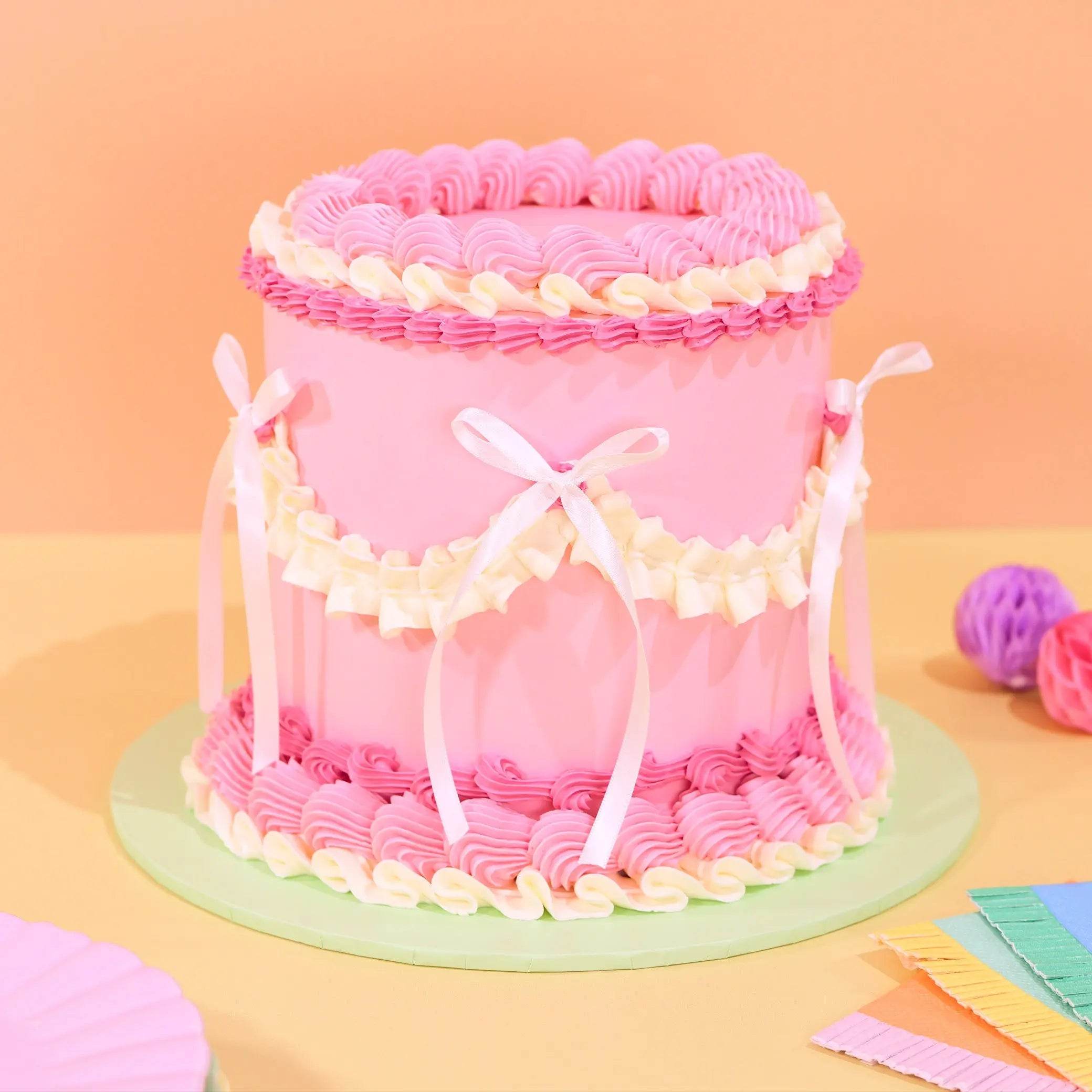 Vintage Cake - Tonal Colour by Crumbs & Doilies with pink Swiss Meringue icing and decorative white ribbons.