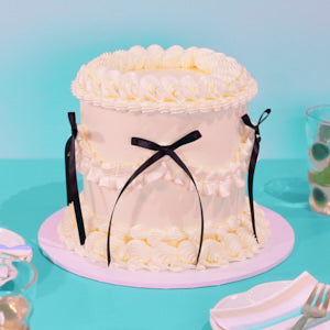 Decorative Vintage cake with white frosting and black ribbons on a blue background