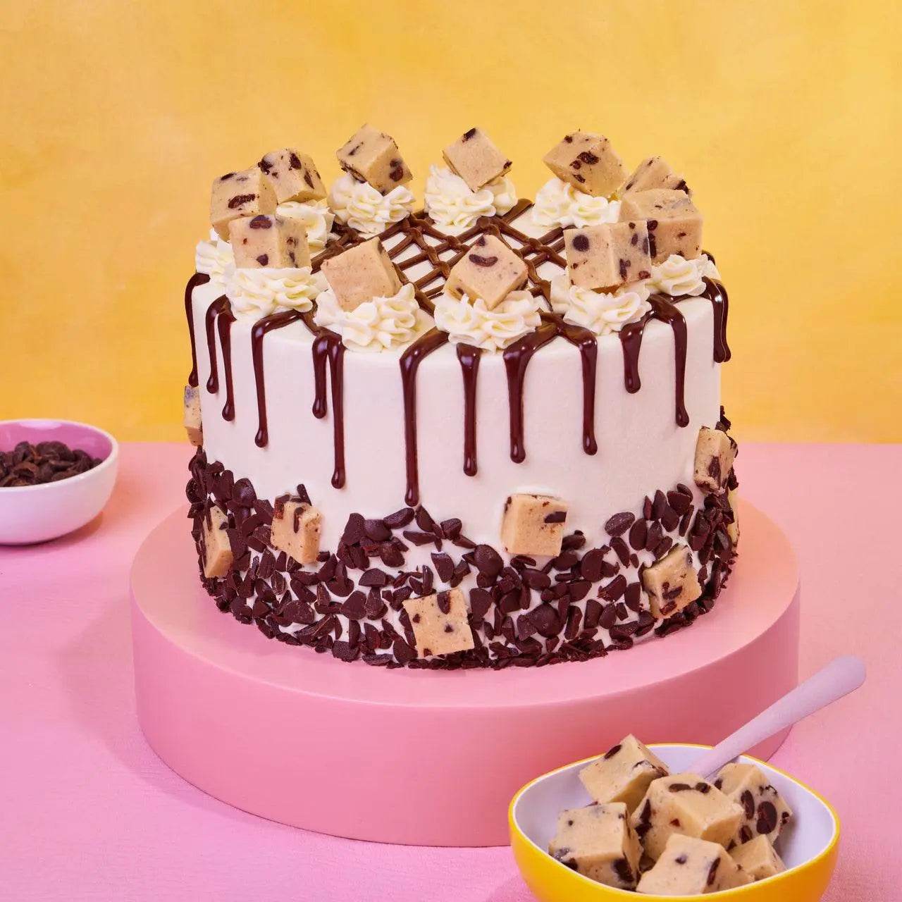Cookie Dough Cake with edible cookie dough chunks, vanilla buttercream, chocolate chips, and chocolate ganache drip by Crumbs & Doilies