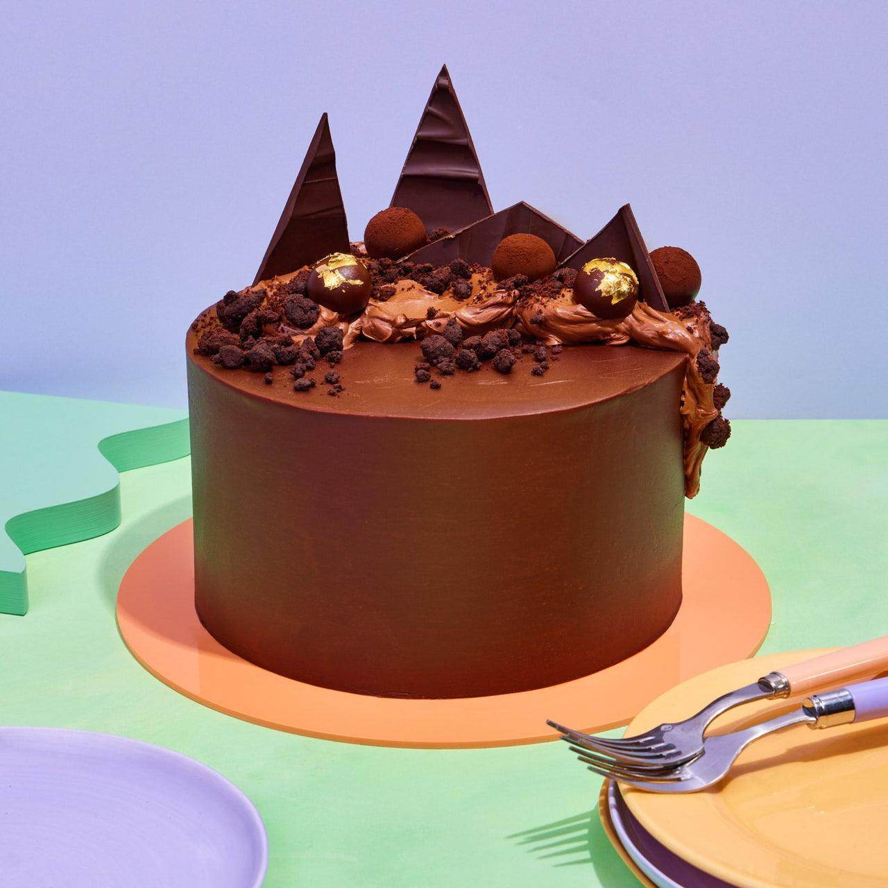 Ultimate Chocolate Cake with smooth dark chocolate ganache, handmade truffles, chocolate shards, and edible 24k gold decoration.