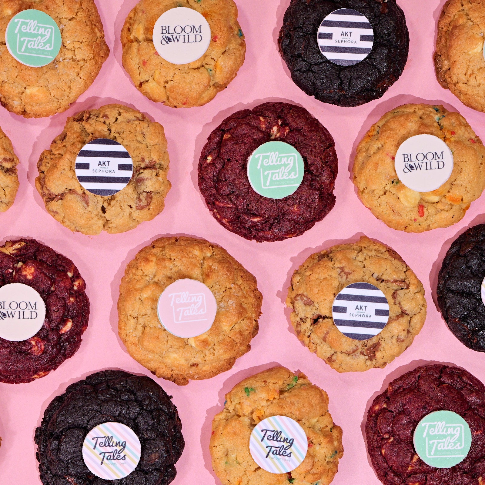 Assorted New York Cookies with Logos featuring colorful branded edible toppers on a soft pink background