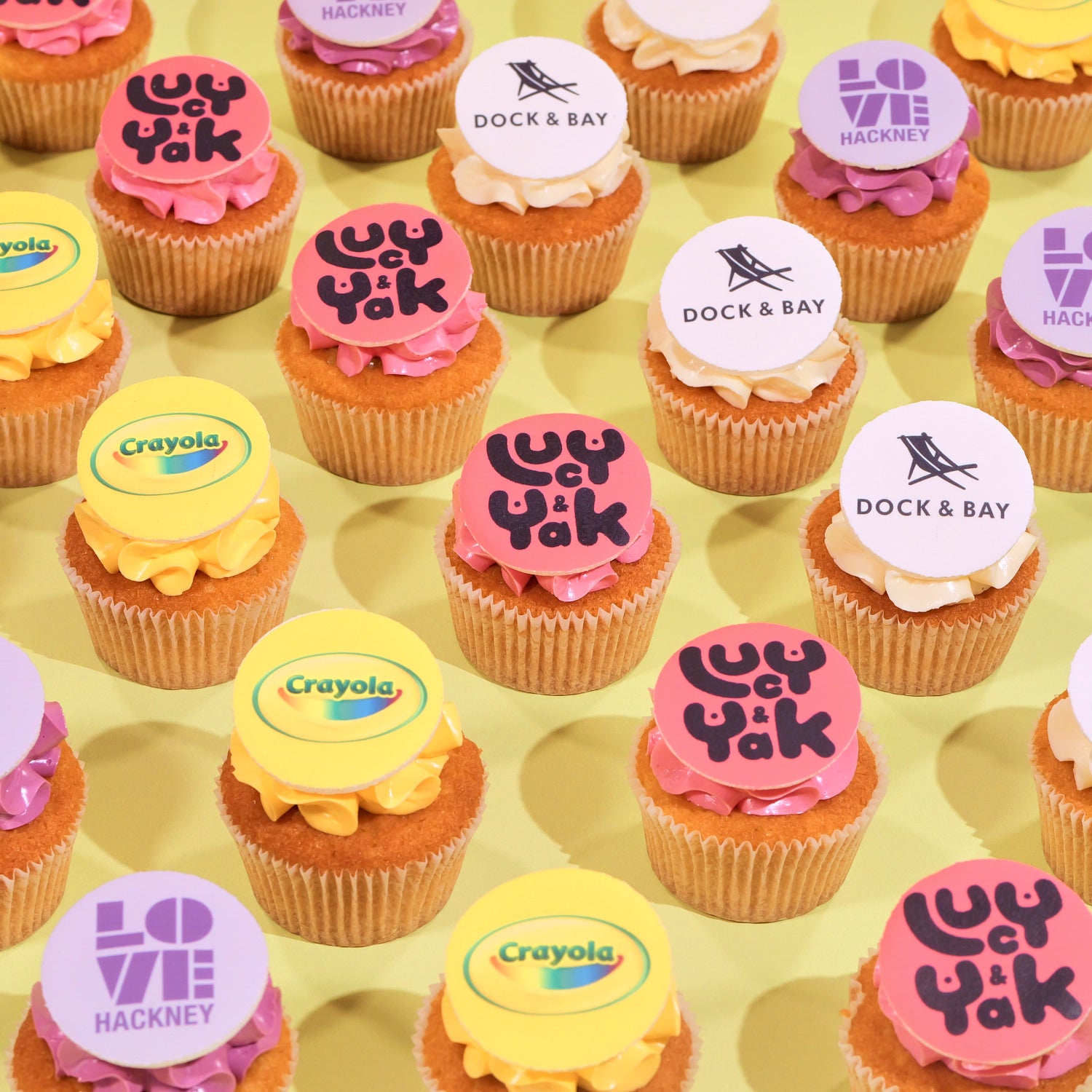 Gluten Free Corporate Cupcakes with Logos featuring colorful branded edible toppers on moist vanilla cupcakes