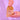 Hand holding a White Chocolate & Pretzel New York Cookie in a Crumbs & Doilies branded paper bag against a purple background
