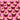 Row of Crumbs & Doilies Red Velvet Cupcakes with cream cheese frosting and red velvet crumbs on pink background