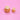 Two freshly baked Vegan Vanilla Cupcakes with plant-based icing and rainbow sprinkles on a pink background by Crumbs & Doilies.