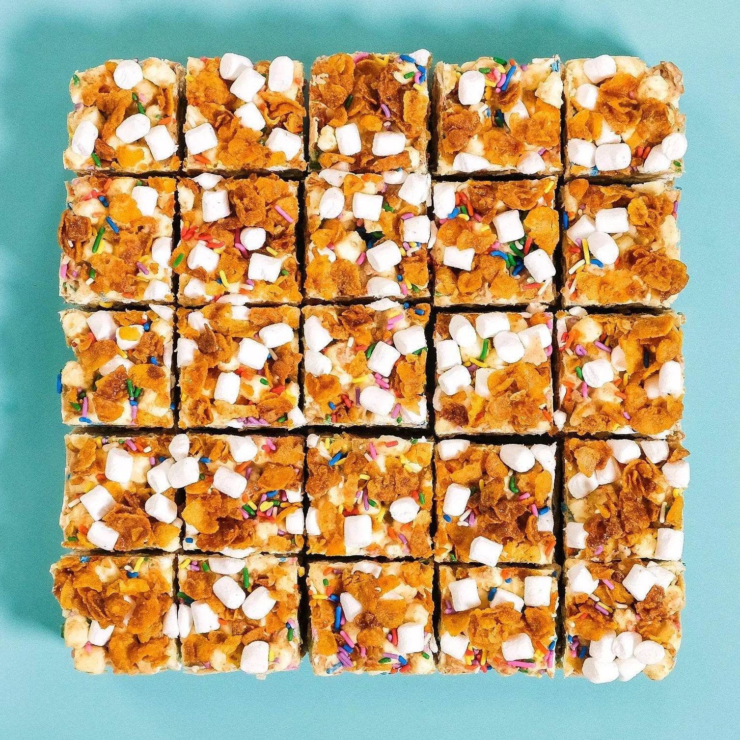 Cereal Milk Rocky Road squares topped with marshmallows, cornflakes and rainbow sprinkles Crumbs & Doilies