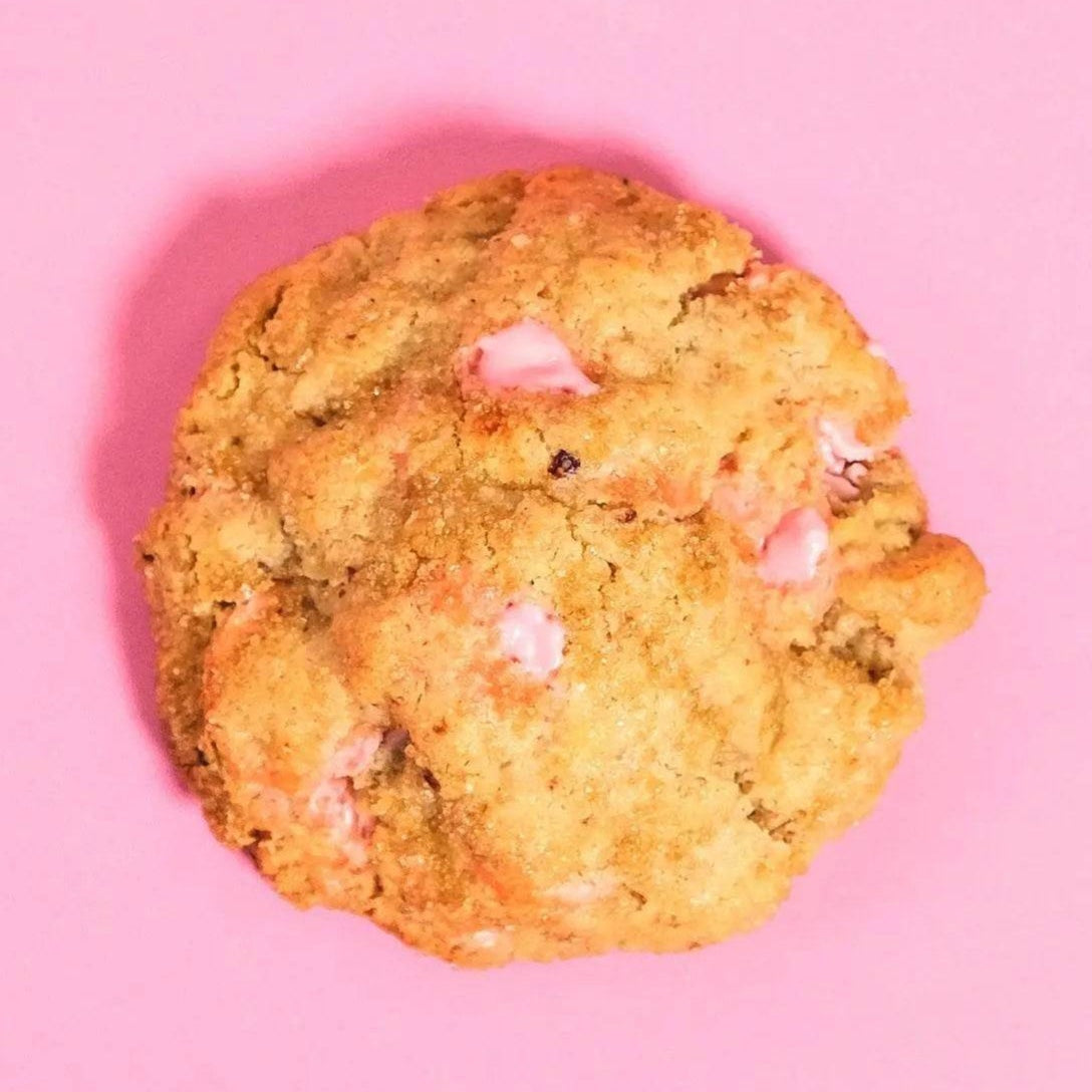 Strawberry Shortcake New York Cookie by Crumbs & Doilies with real strawberry pieces and chocolate chips on pink background.